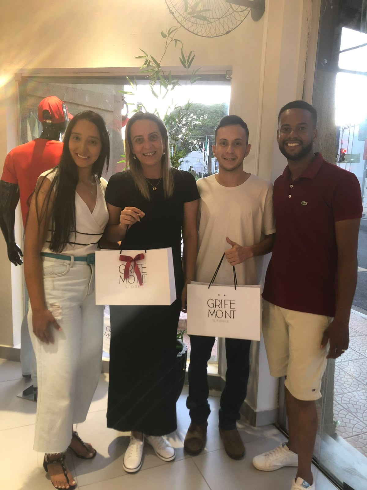 Clientes com Guilherme e Mirian segurando sacolas da Grife Mont